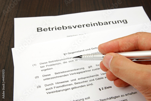 Betriebsvereinbarung mit Hand und Kugelschreiber