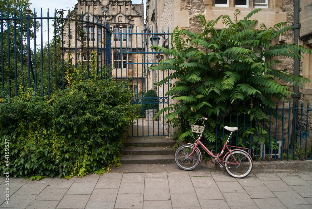 Bicycle parked in front a Trinity College Oxford gate