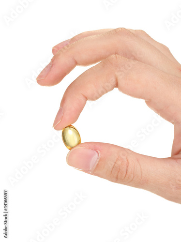 woman's hand holds a pellets of fish oil