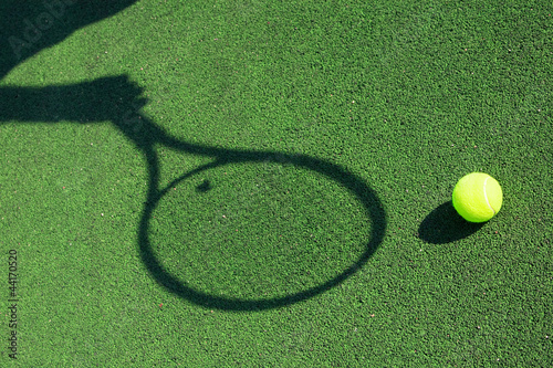 shadow of a tennis racket in hand with a ball © smailik