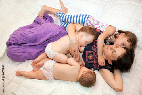 Breast feeding two little sisters twin girls at the same time.