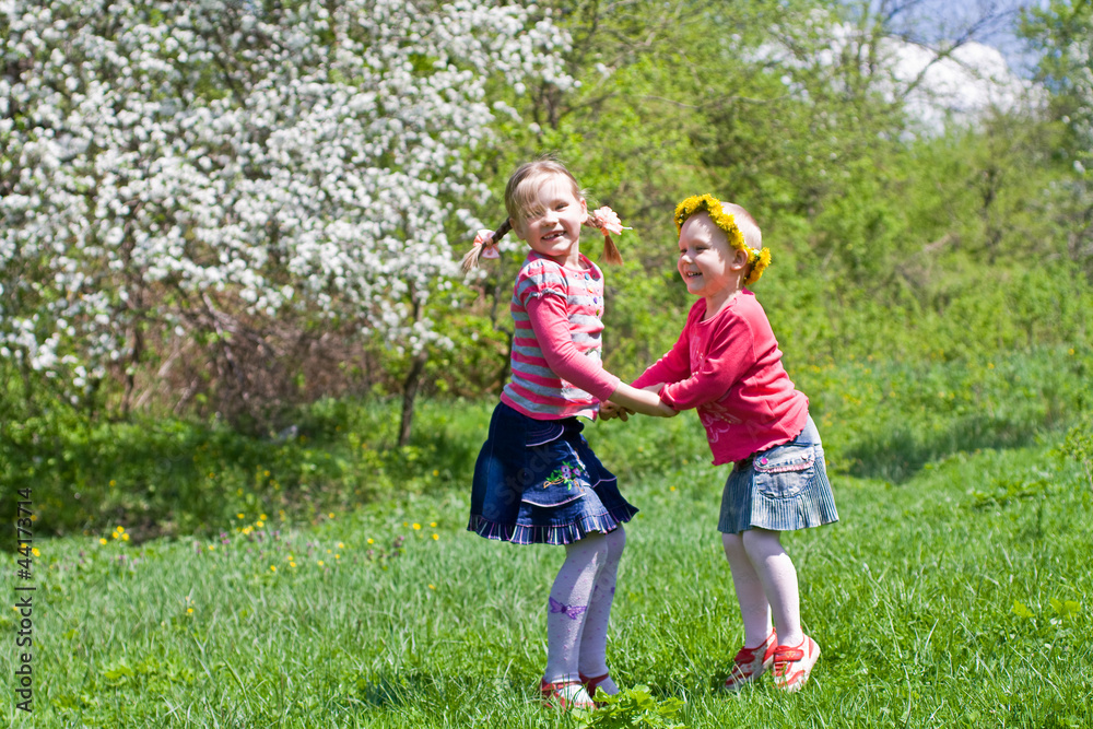 Little girls playing on a spring meadow