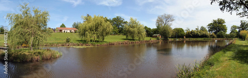 Panorama of a rural property with a house and a pond, France