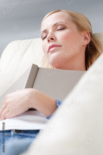 Young girl fall asleep while reading a book