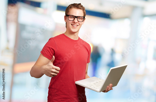 Man holding laptop with thumbs up Free Download Man holding laptop with thumbs up - GFXLoad