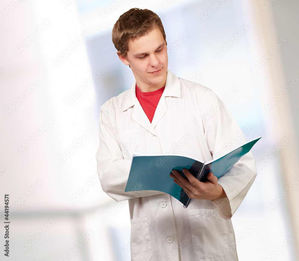 Portrait of a young doctor reading a folder Portrait of a young doctor reading a folder