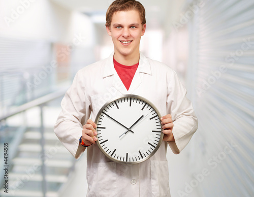 Portrait of a doctor holding a clock