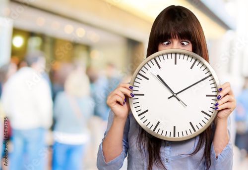 Woman Holding Clock With Squinted Eyes photo
