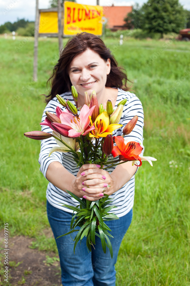 Young woman with lily bouquet in hands on green field Young woman with lily bouquet in hands on green field