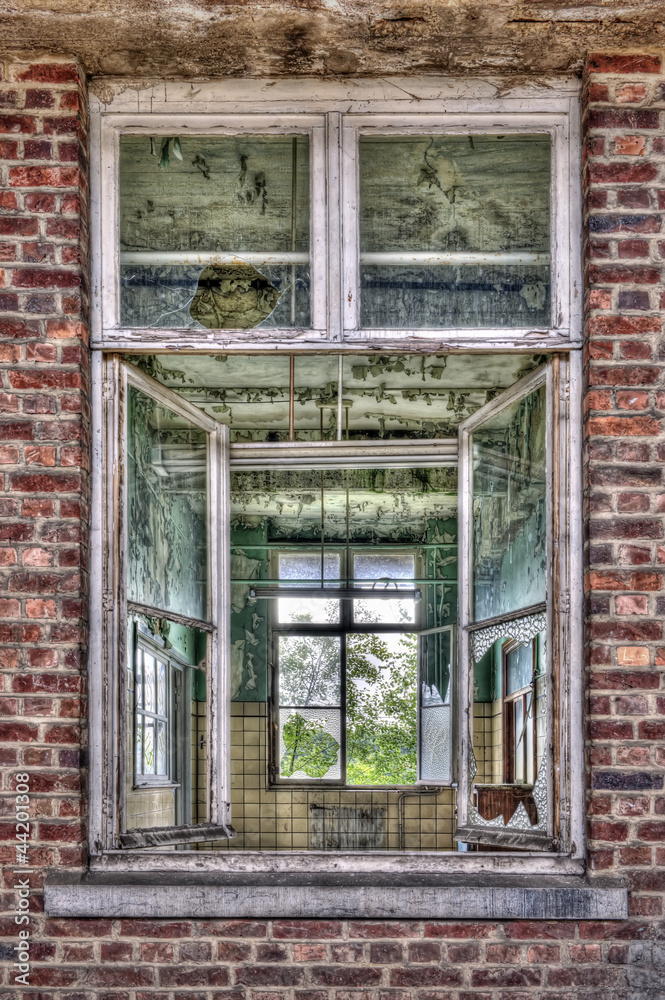 Broken windows in red brick wall in an abandoned railway station