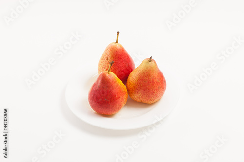 Ripe yellow pear on white plate