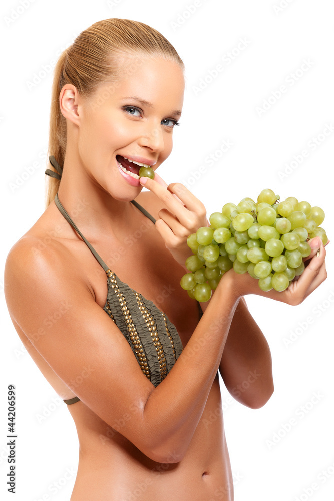 young woman enjoys eating some grapes young woman enjoys eating some grapes
