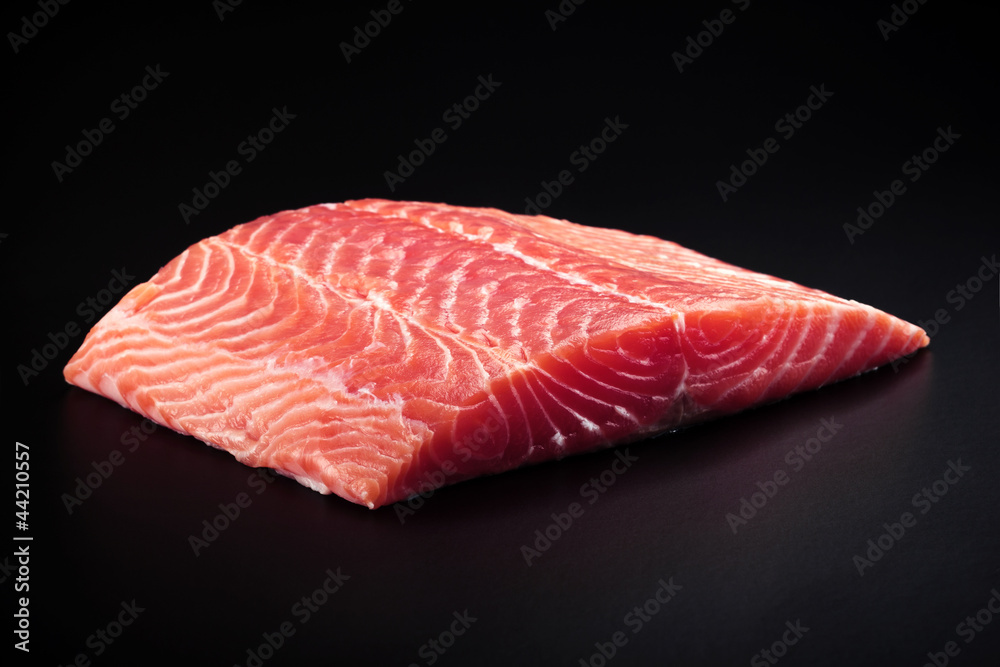 fresh salmon steak over black background