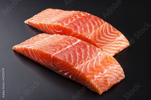 fresh salmon steak over black background