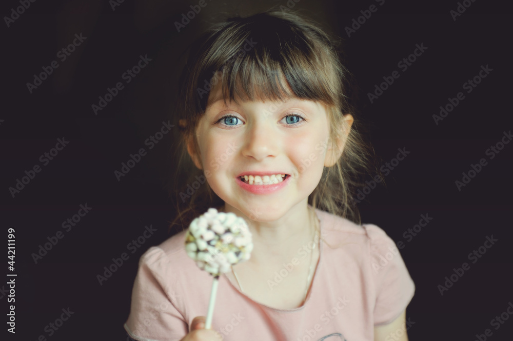 Funny child girl showing a marshmallow cake Funny child girl showing a marshmallow cake