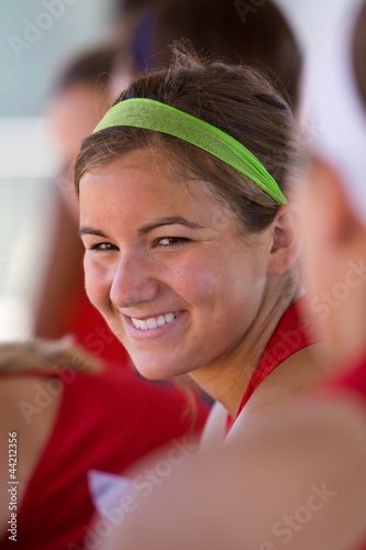 Female Softball Player Smiles From Inside Dugout