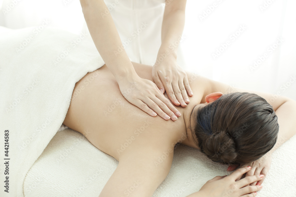 背中をマッサージするエステティシャン