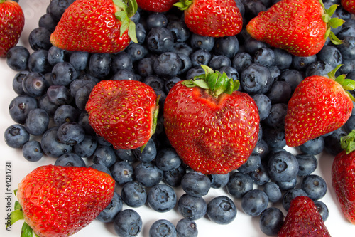 Blueberries and strawberries on white