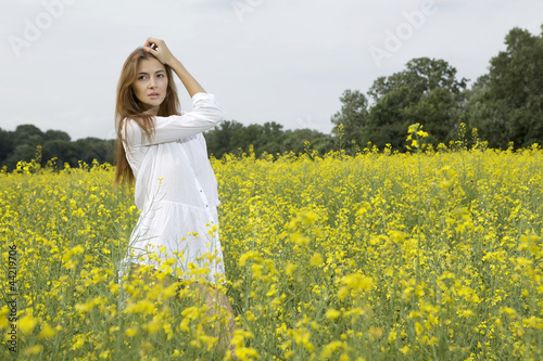 brunette woman in a yellow flowers field © bartekwardziak