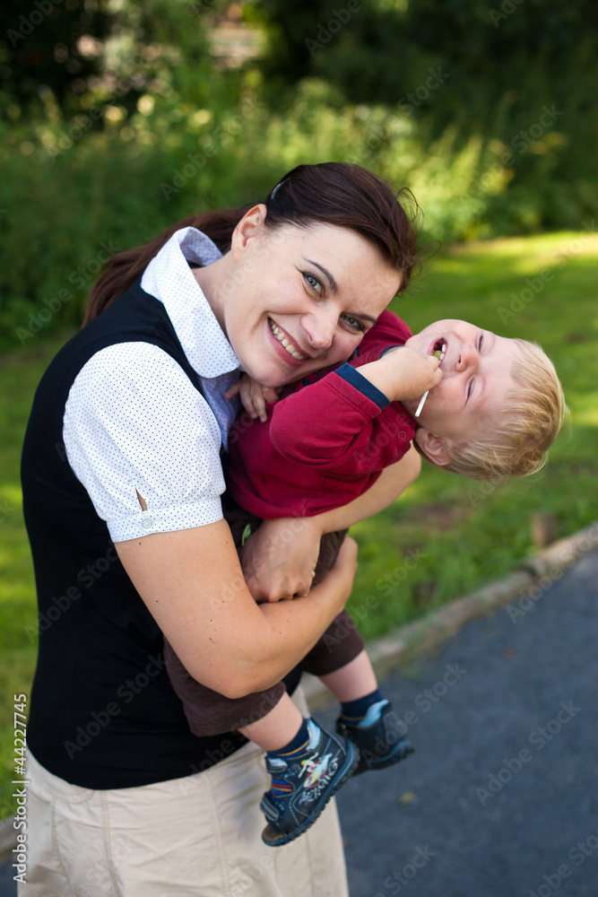 Young mother and her toddler walking through nature park Young mother and her toddler walking through nature park