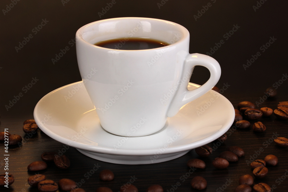 Obraz premium Cup of coffee on wooden table on brown background