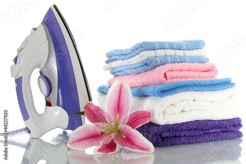 Fototapeta Naklejka Na Ścianę i Meble -  Pile of clothes with lily and electric iron, isolated on white
