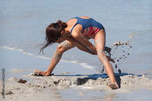 Mädchen buddelt im Sand photo