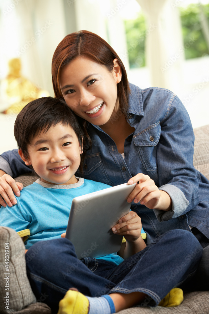 Chinese Mother And Son Using Tablet Computer Whilst On Sofa Stock Photo |  Adobe Stock