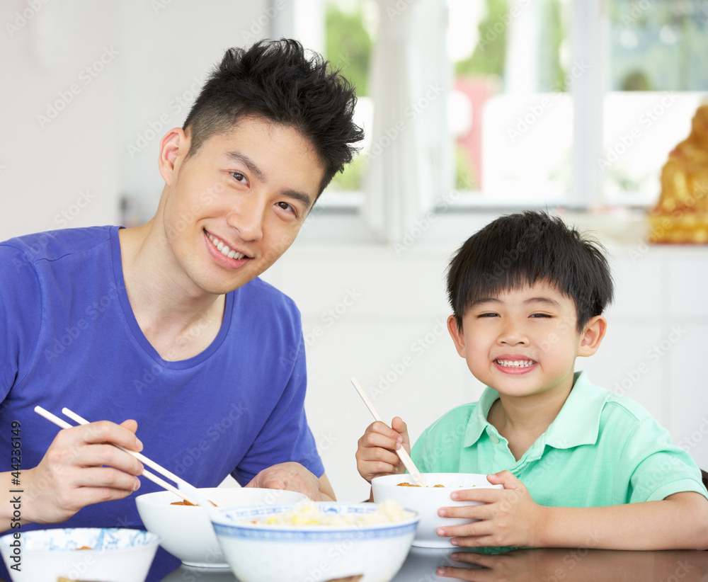 Chinese Father And Son Sitting At Home Eating A Meal Chinese Father And Son Sitting At Home Eating A Meal