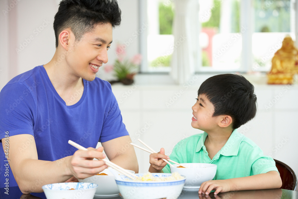 Chinese Father And Son Sitting At Home Eating A Meal Chinese Father And Son Sitting At Home Eating A Meal