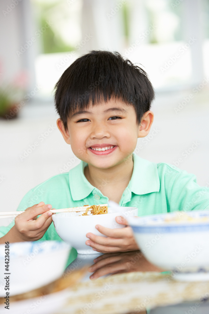 Young Chinese Boy Sitting At Home Eating Meal Young Chinese Boy Sitting At Home Eating Meal