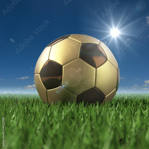 Fussball gold schwarz 3D auf Rasen unter Sommerlichen Himmel