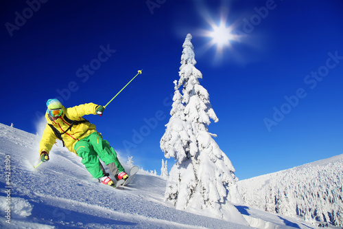 Skier skiing downhill in mountains