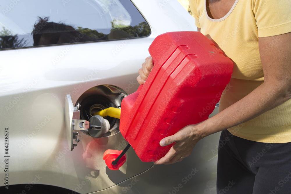 Adding fuel in car with plastic can Adding fuel in car with plastic can