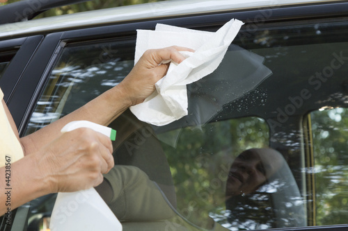 Cleaning the car window with paper towel, close up
