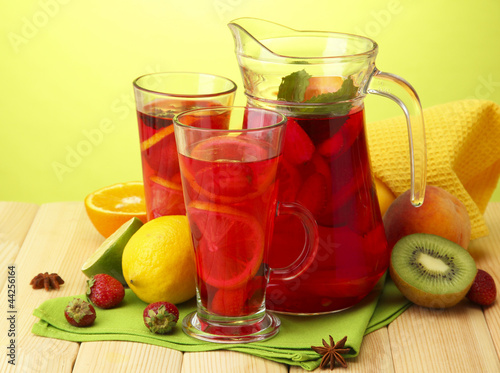sangria in jar and glasses with fruits,