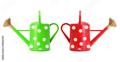 Foto red and green polka dot watering cans isolated on white