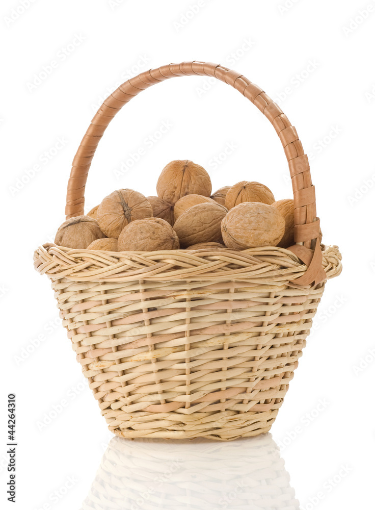 walnuts in basket wicker isolated on white