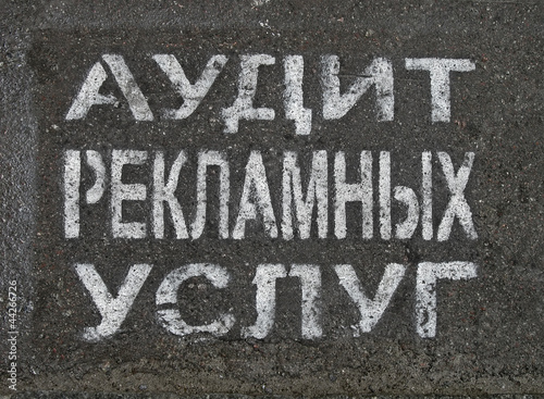 advertising service audit as painted text on russian on asphalt,