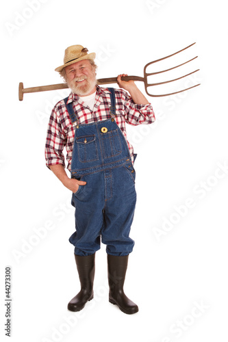 Happy senior farmer lifting hay fork up