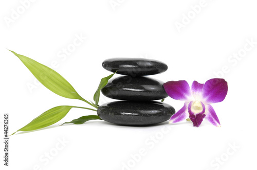 stacked stones and pink orchid with green leaf