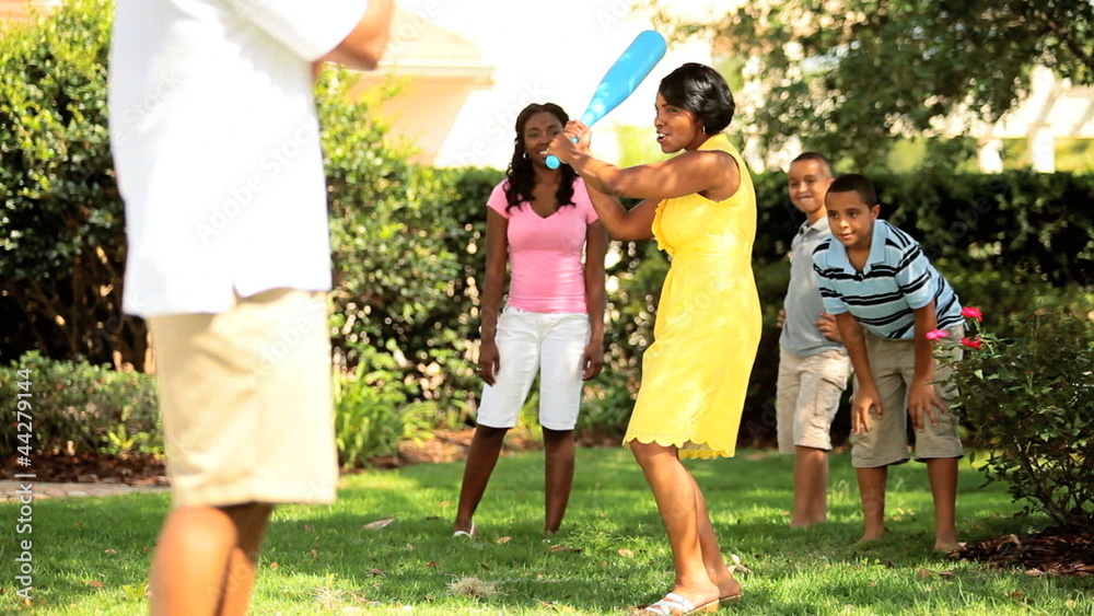 Ethnic mother and father playing baseball with children Ethnic mother and father playing baseball with children