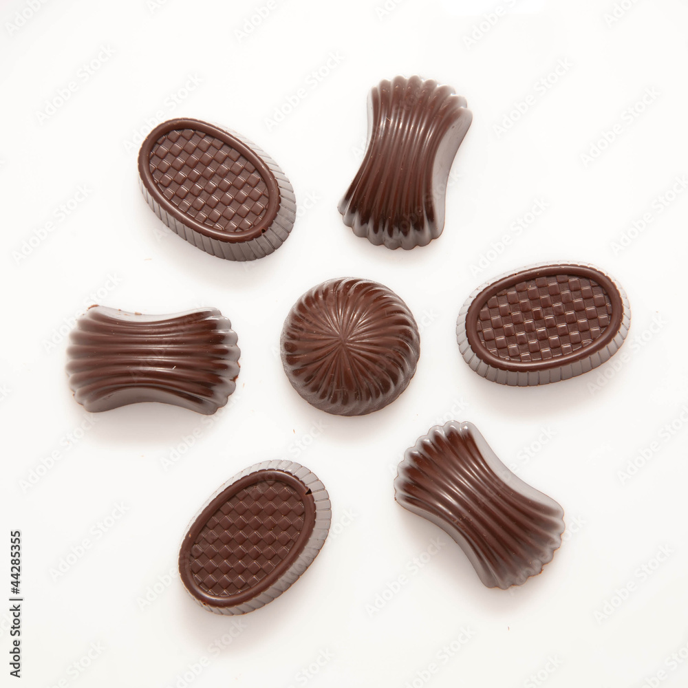 Delicious flower formed from various chocolate candies on white Delicious flower formed from various chocolate candies on white