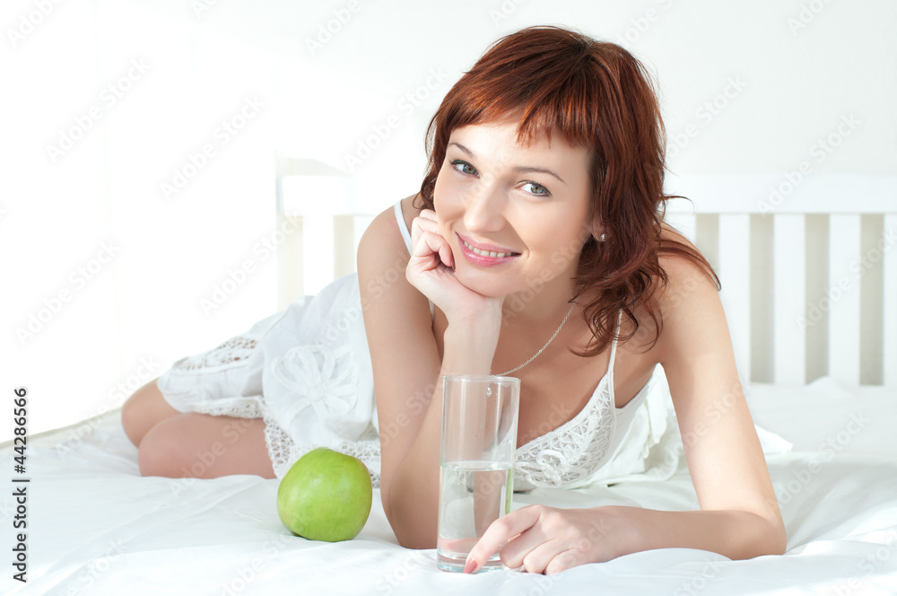 attractive young woman with an green apple and glass of water attractive young woman with an green apple and glass of water
