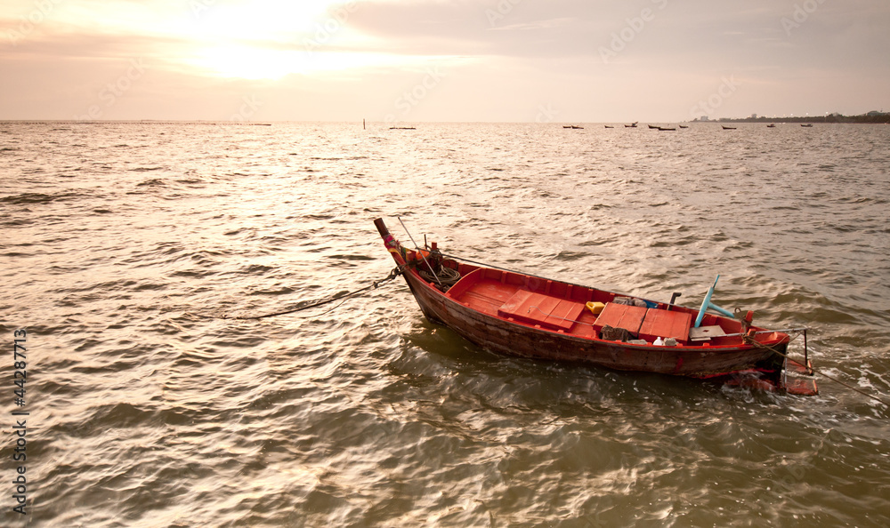 A small wooden fishing boat  floating in the sea