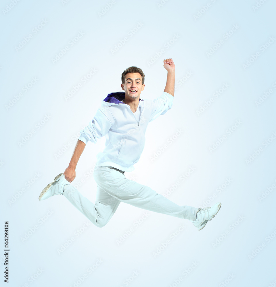 Jumping young man. Isolated over blue background