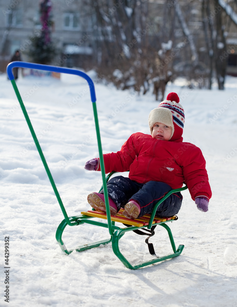 toddler on sled  in winter