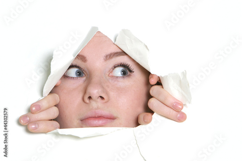 young girl looking through hole in paper