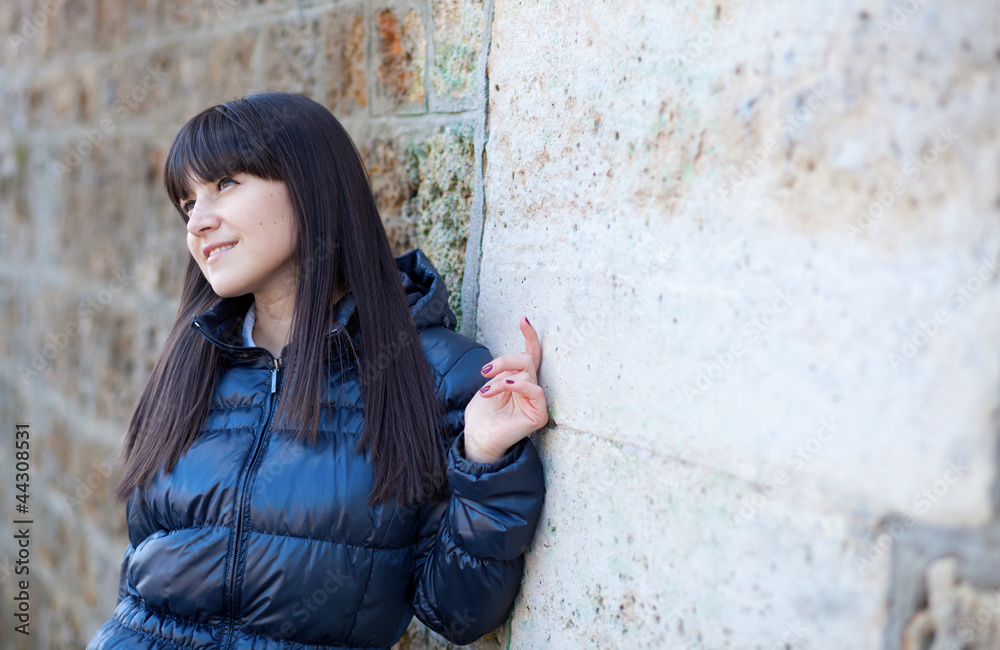 Portrait of beautiful brunette woman in front of the wall Portrait of beautiful brunette woman in front of the wall
