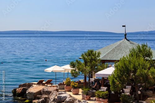 Fototapeta Naklejka Na Ścianę i Meble -  Two Loungers Under Sun Umbrella at the Beach Restaurant in Opati